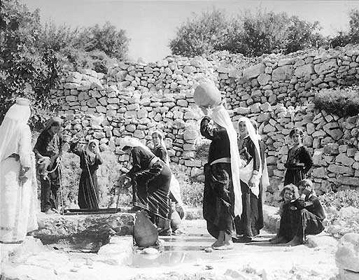 Palestinian women gathering water at the village well