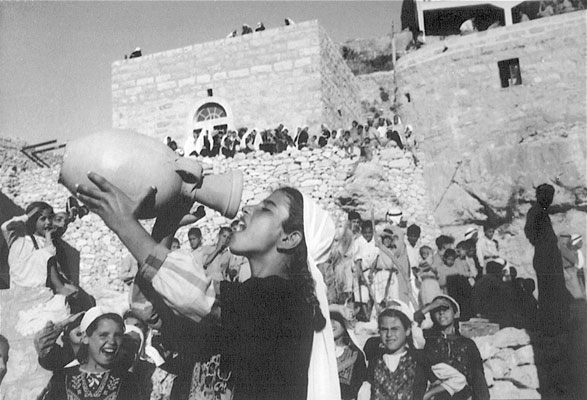 Palestinian girl drinking from water jug